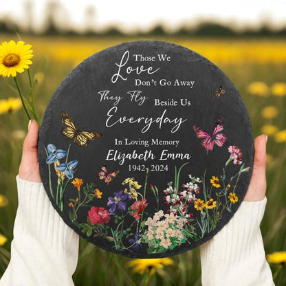 Butterfly memorial stone held in wildflower field