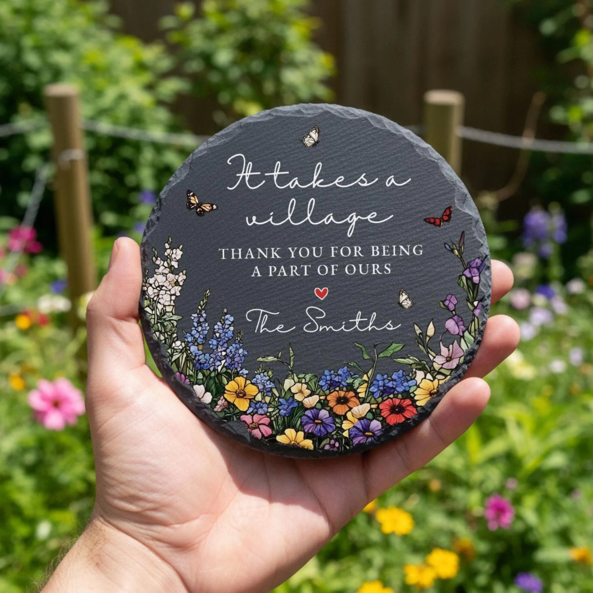 It takes a village slate stone with family name held in garden
